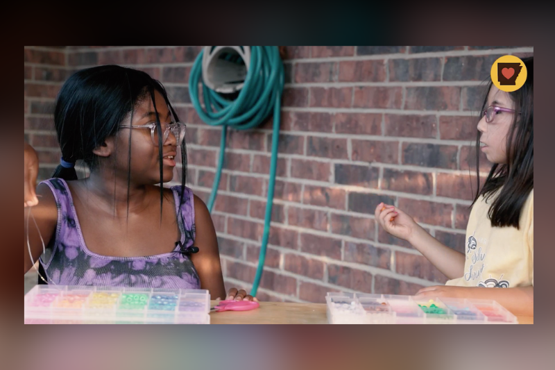 Cydney talking with a friend and making jewelry