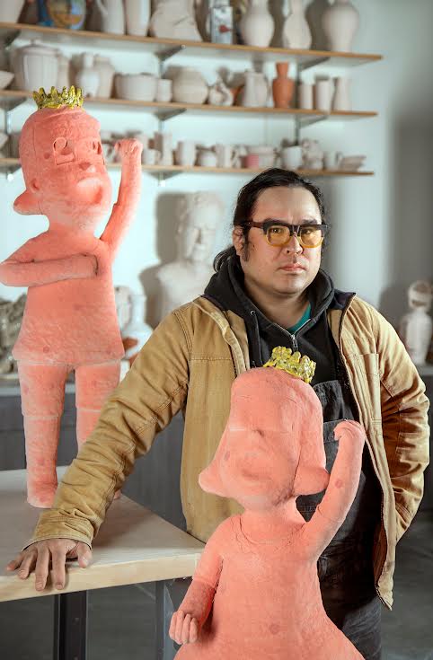 Ceramics professor Kensuke Yamada standing beside his art