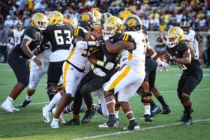 UAPB football players tackling an opponent