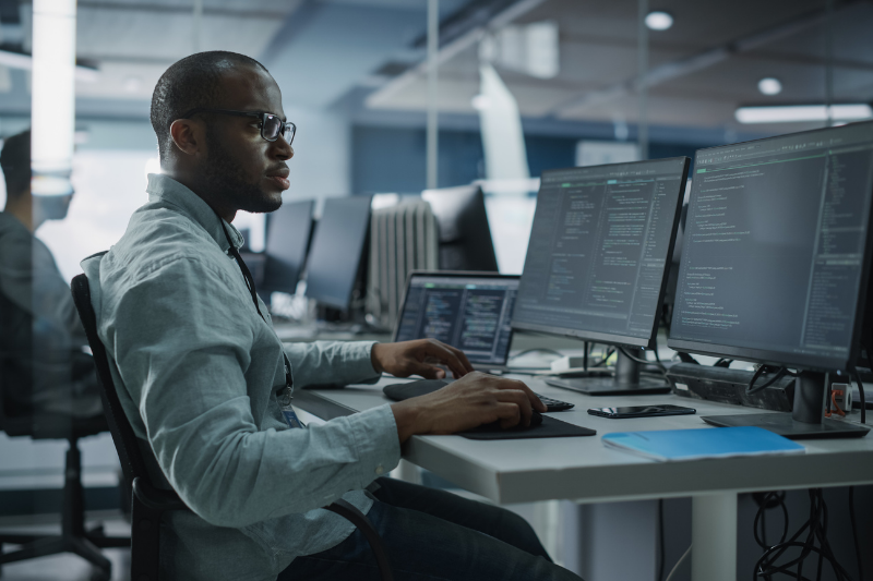 Professional Black IT Programmer Working on Desktop Computer