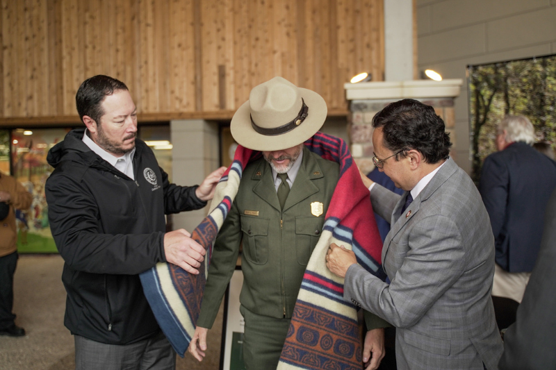 Deputy Chief Bryan Warner, left, and Principal Chief Chuck Hoskin Jr., right, presented Mark Foust, National Park Service Superintendent at Buffalo National River in Arkansas, with a tribal sovereignty blanket during a special ceremony Apr. 20, 2022 in Tahlequah, Okla., marking a new partnership between the tribe and NPS.